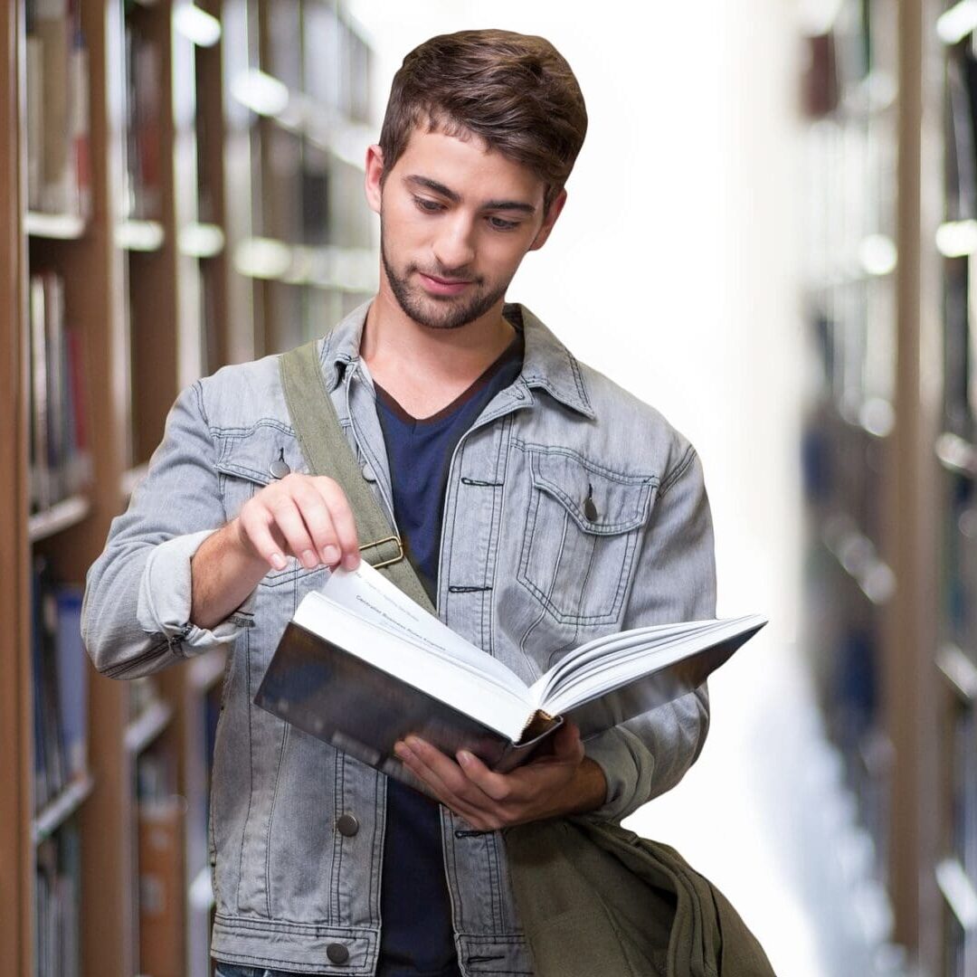 A man is reading a book in the library.